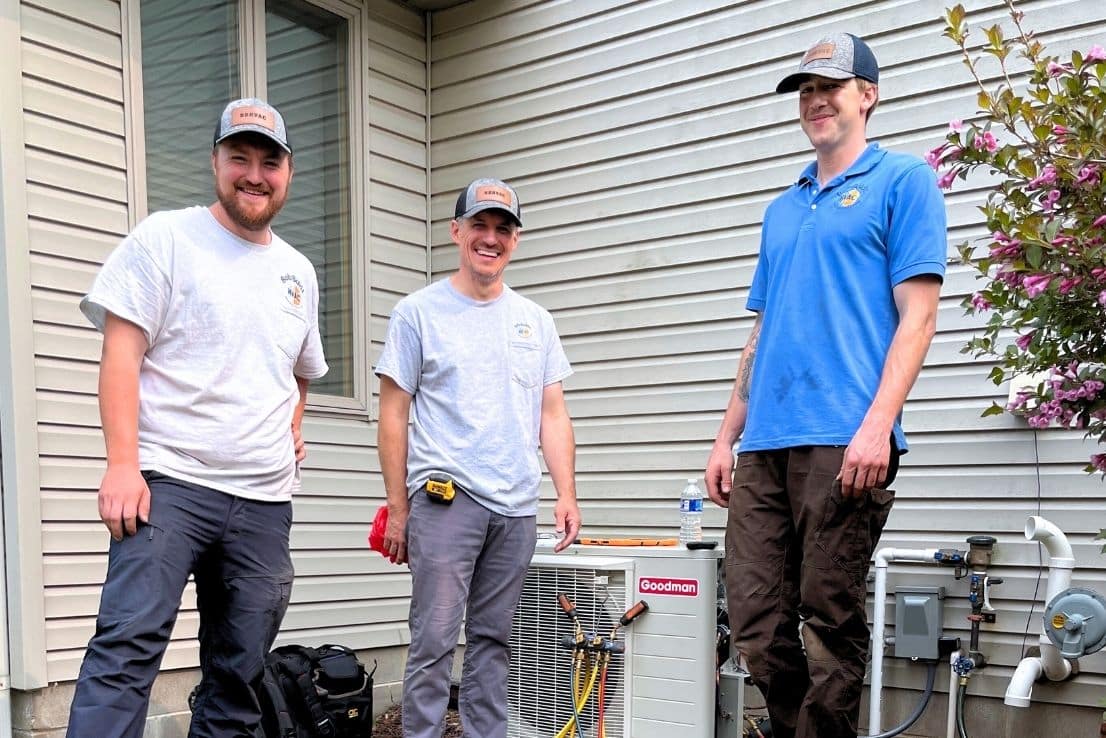 Bob Boldt HVAC's Team of Trained and Certified Heating and Cooling Professionals Standing By An Air Conditioning Unit